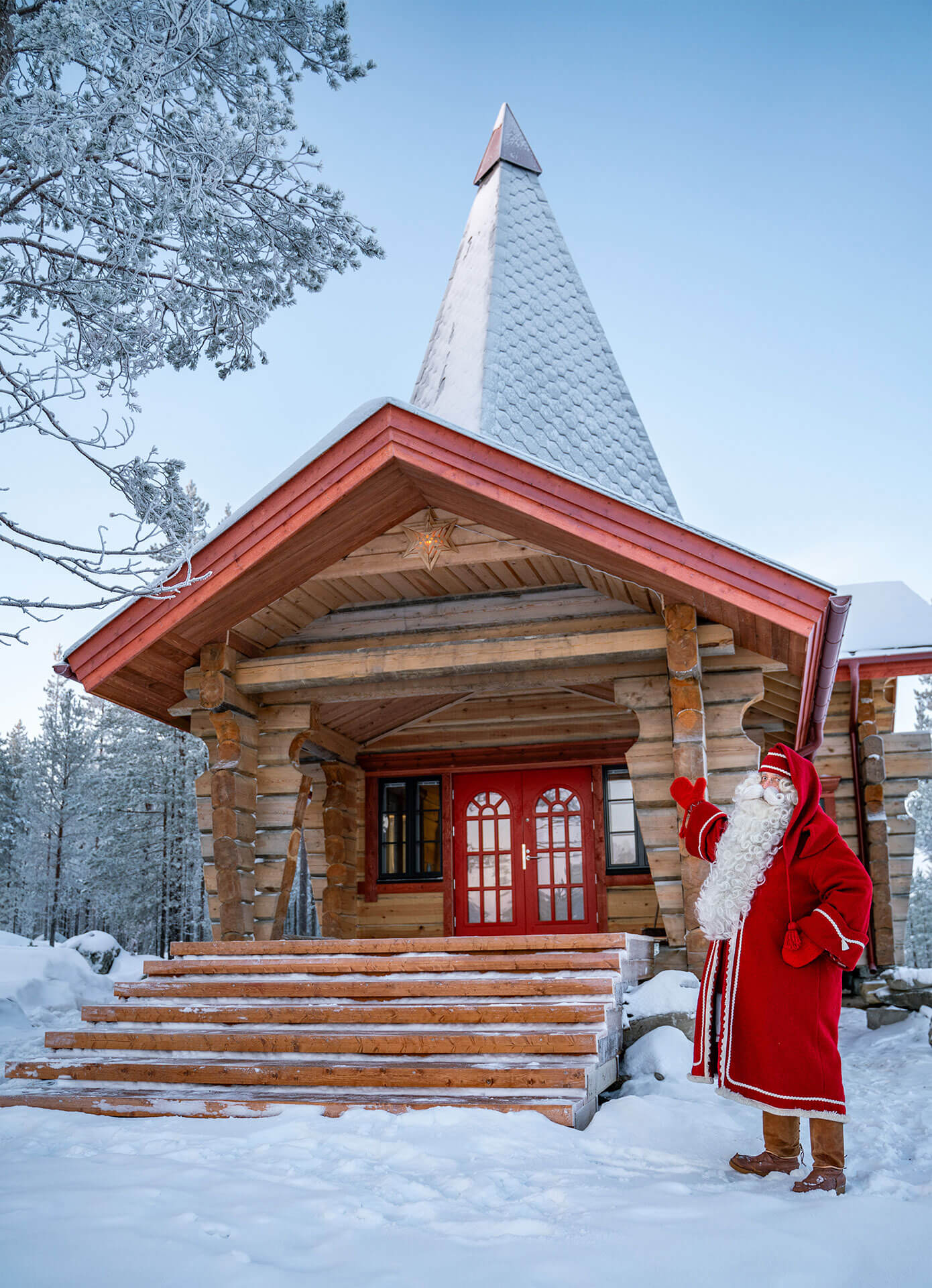 Santa Claus greeting visitors at the cottage entrance